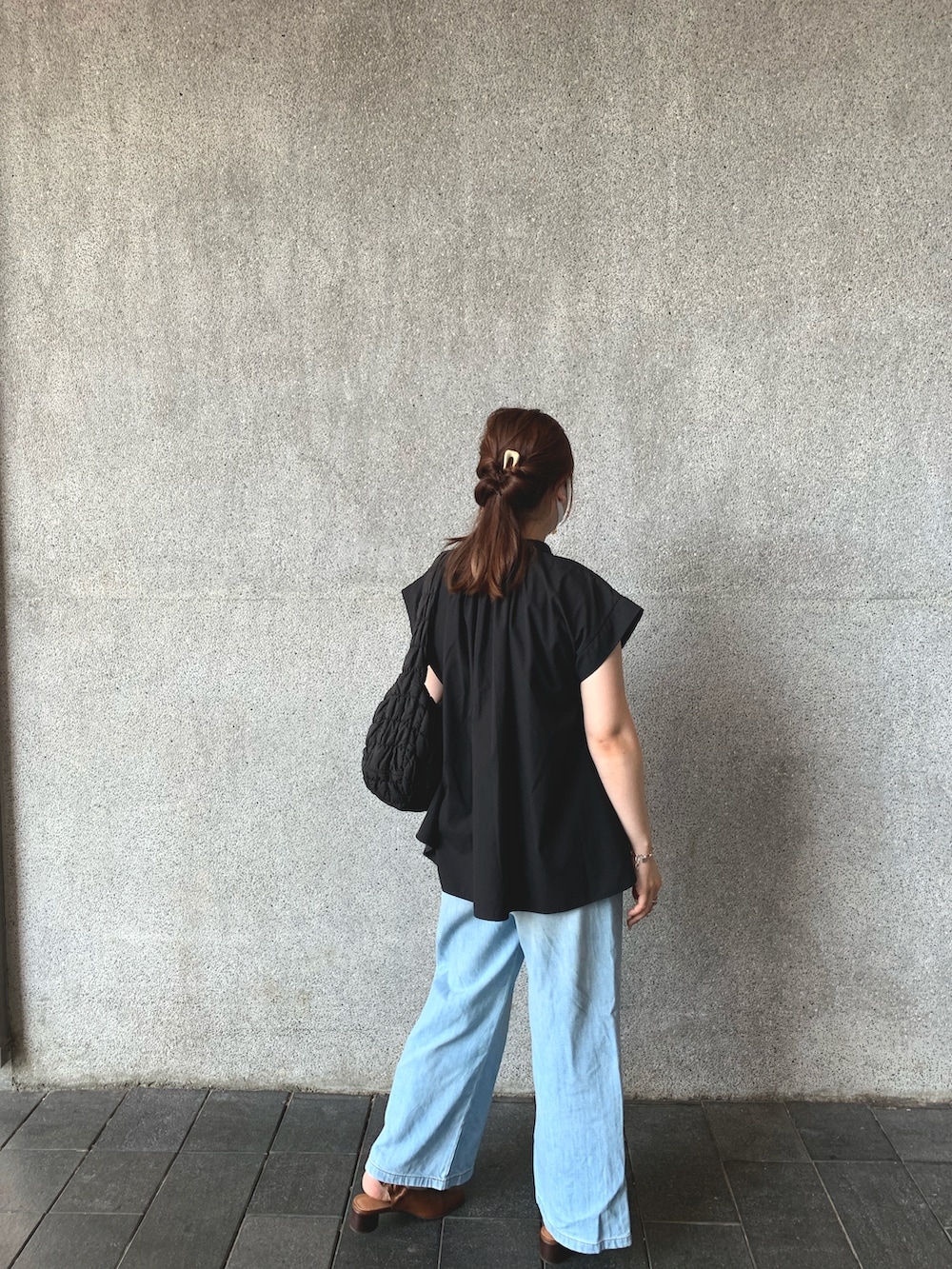 ブラック系のシャツ/ブラウス、ブラウン系のパンプス、ブルー系のパンツを着用したレディースの夏コーディネートの2枚目の写真