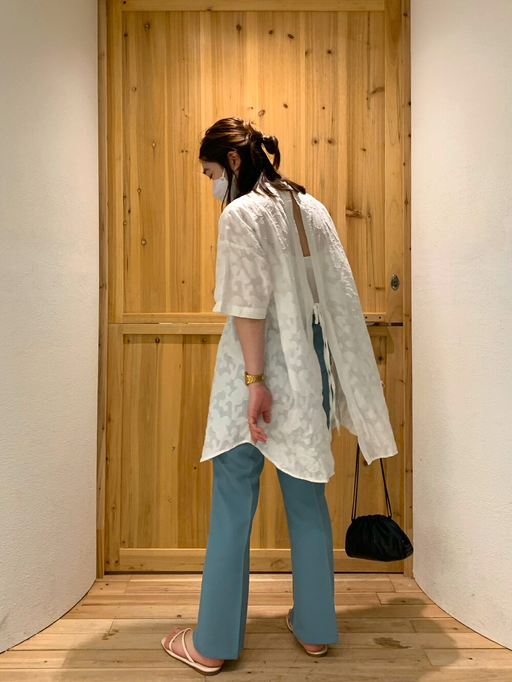 ブルー系のその他パンツ、ブラック系のクラッチバッグ、ホワイト系のシャツ/ブラウスを着用したレディースの春コーディネートの2枚目の写真