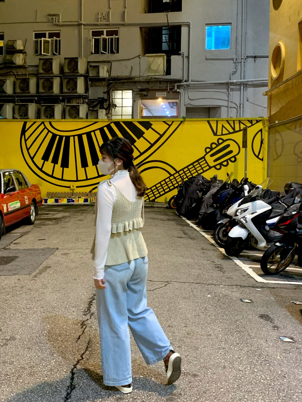 グレー系のニット/セーター、ホワイト系のTシャツ/カットソー、ブルー系のパンツを着用したレディースの秋コーディネートの3枚目の写真