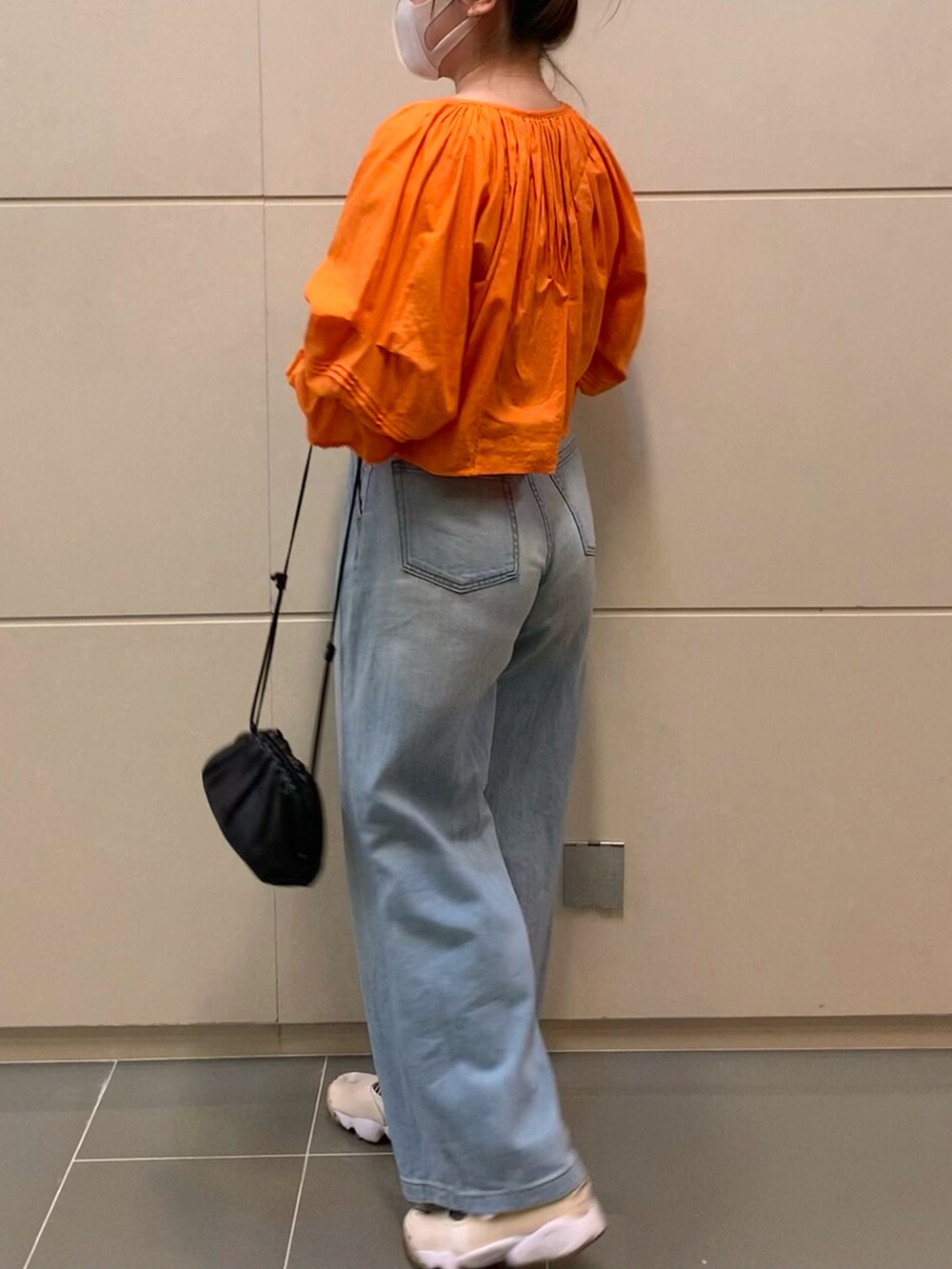 オレンジ系のシャツ/ブラウス、ベージュ系のタンクトップ、ホワイト系のスニーカーを着用したレディースの夏コーディネートの2枚目の写真