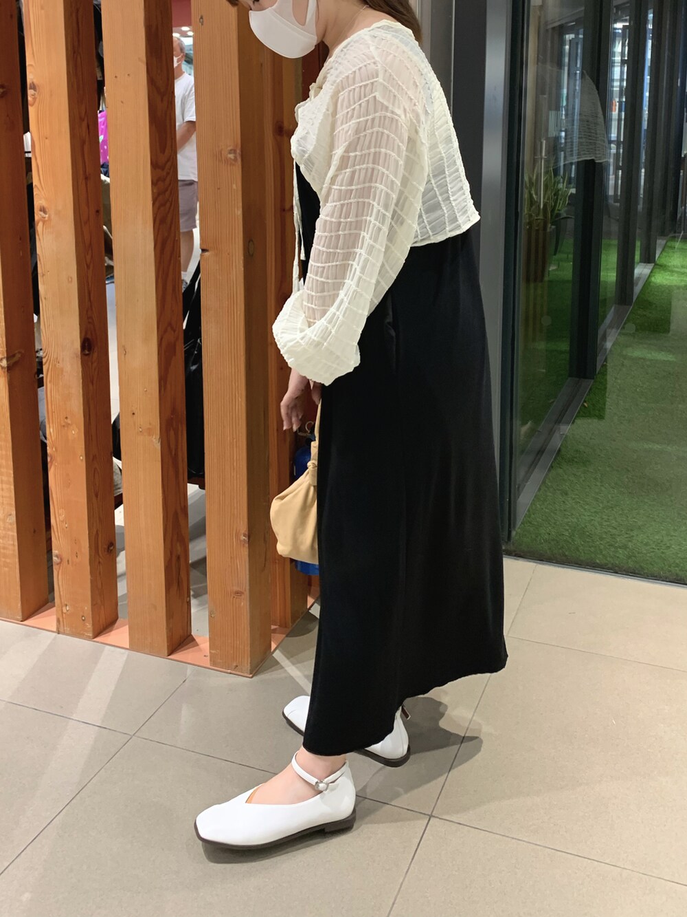 ホワイト系のカーディガン/ボレロ、ブラック系のワンピース、ホワイト系のパンプスを着用したレディースの夏コーディネートの2枚目の写真