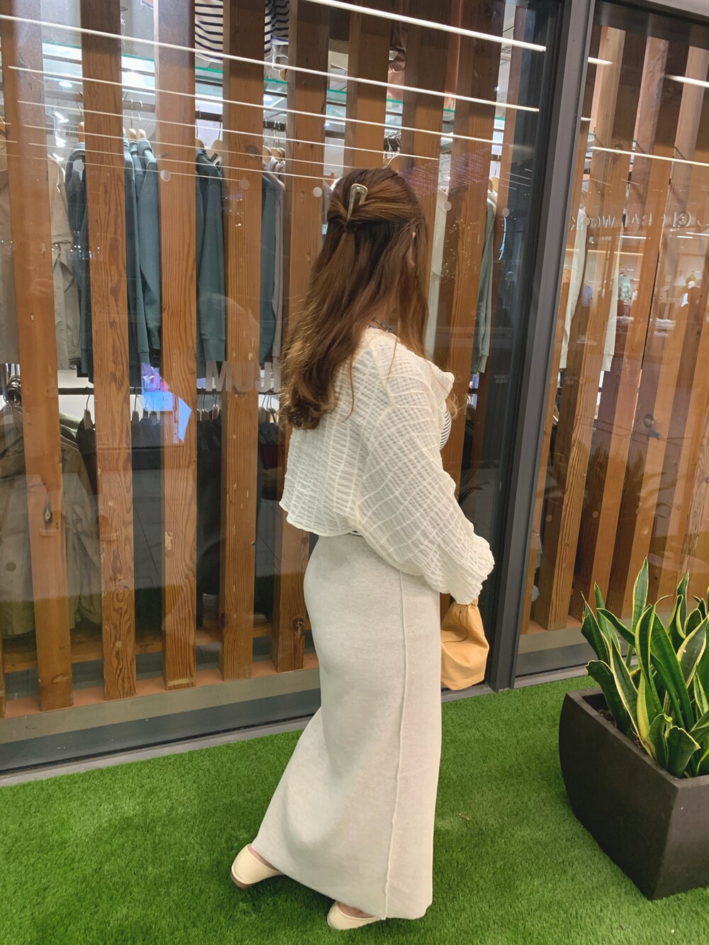 ホワイト系のTシャツ/カットソー、ベージュ系のバッグ、ベージュ系のスカートを着用したレディースの春コーディネートの3枚目の写真