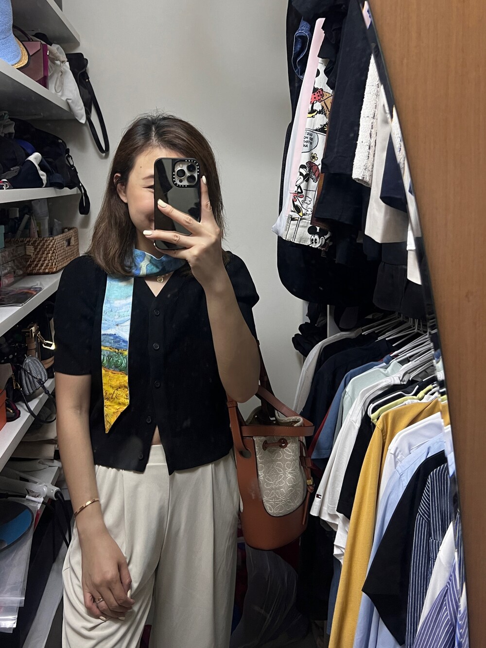 ブラック系のニット/セーター、ベージュ系のその他パンツ、ブラウン系のショルダーバッグを着用したレディースの夏コーディネートの2枚目の写真