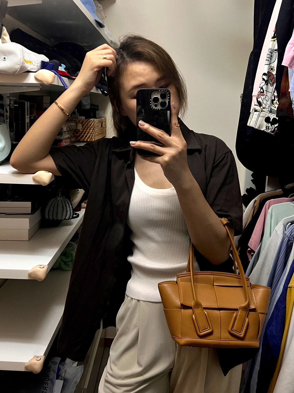 ブラウン系のバッグ、ベージュ系のその他パンツ、ホワイト系のタンクトップを着用したレディースの夏コーディネートの3枚目の写真