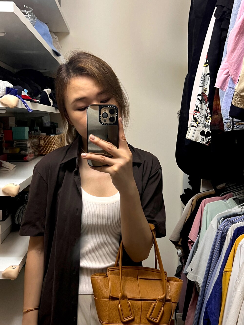 ブラウン系のバッグ、ベージュ系のその他パンツ、ホワイト系のタンクトップを着用したレディースの夏コーディネートの2枚目の写真