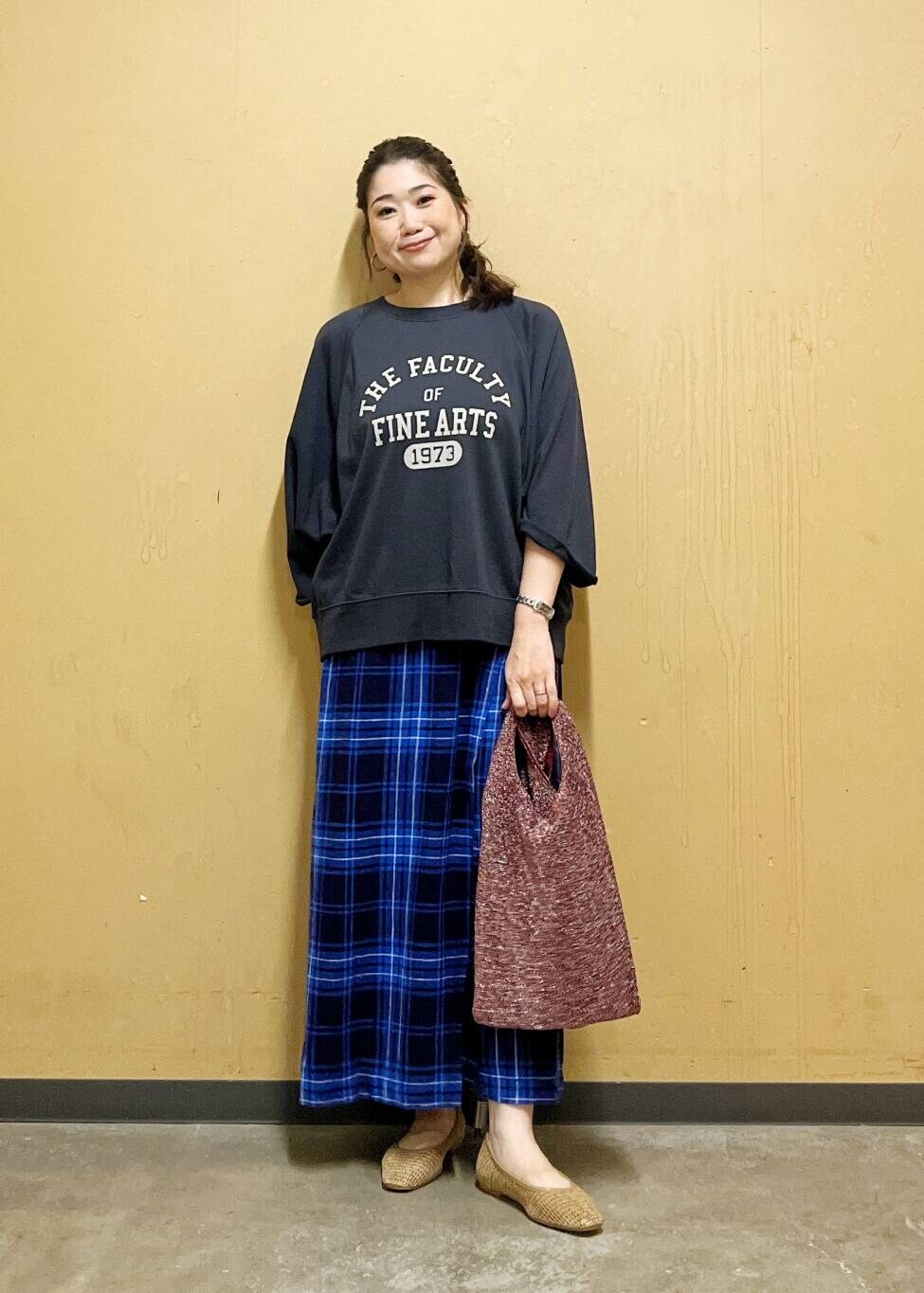 ブルー系のスカート、ベージュ系のパンプス、ブラック系のTシャツ/カットソーを着用したレディースの夏コーディネートの5枚目の写真