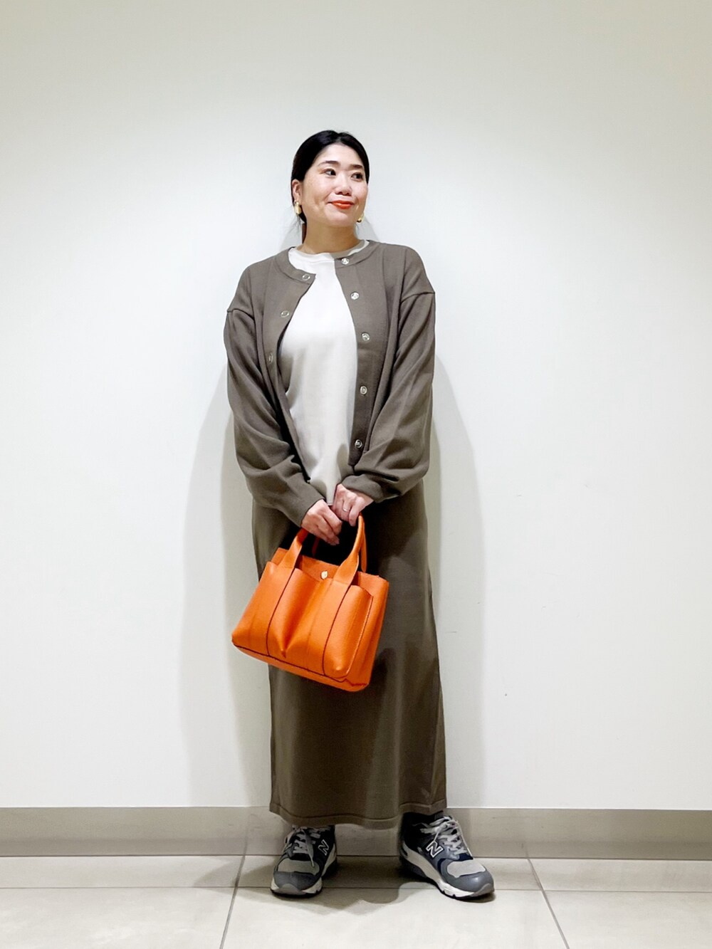 ベージュ系のTシャツ/カットソー、ブラウン系のカーディガン/ボレロ、ブラウン系のスカートを着用したレディースの秋コーディネートの5枚目の写真