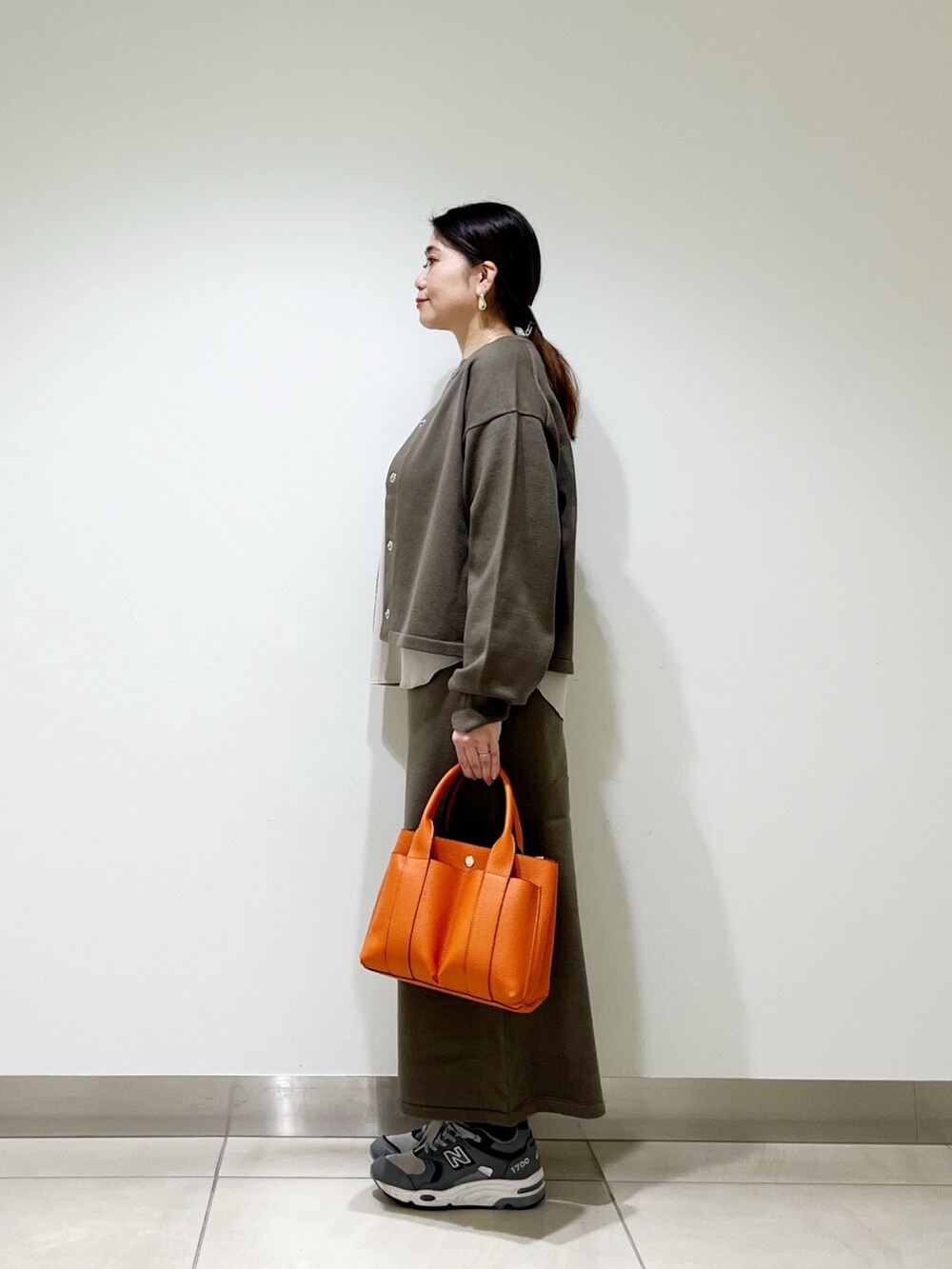 ベージュ系のTシャツ/カットソー、ブラウン系のカーディガン/ボレロ、ブラウン系のスカートを着用したレディースの秋コーディネートの6枚目の写真