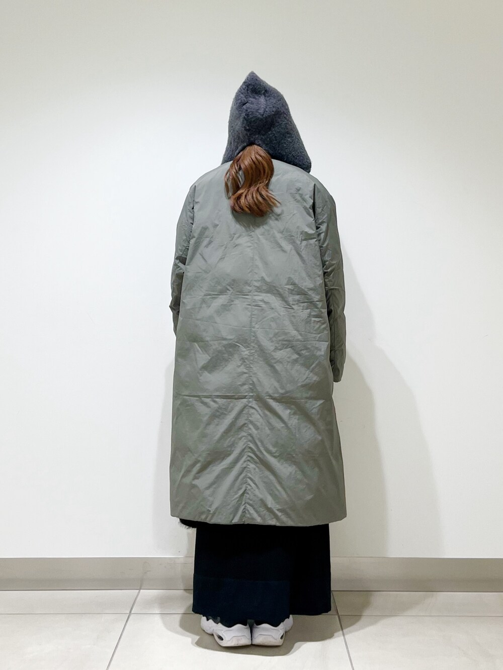 グリーン系のその他アウター、ブラック系のワンピース、ブラック系のハンドバッグを着用したレディースの冬コーディネートの3枚目の写真