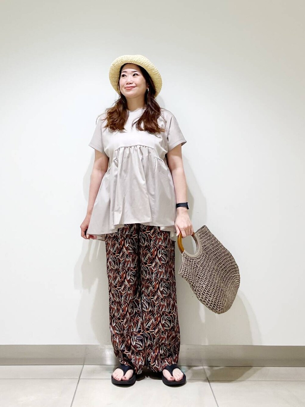 ブラック系のサンダル、グレー系のトートバッグ、ブルー系のその他パンツを着用したレディースの夏コーディネートの2枚目の写真