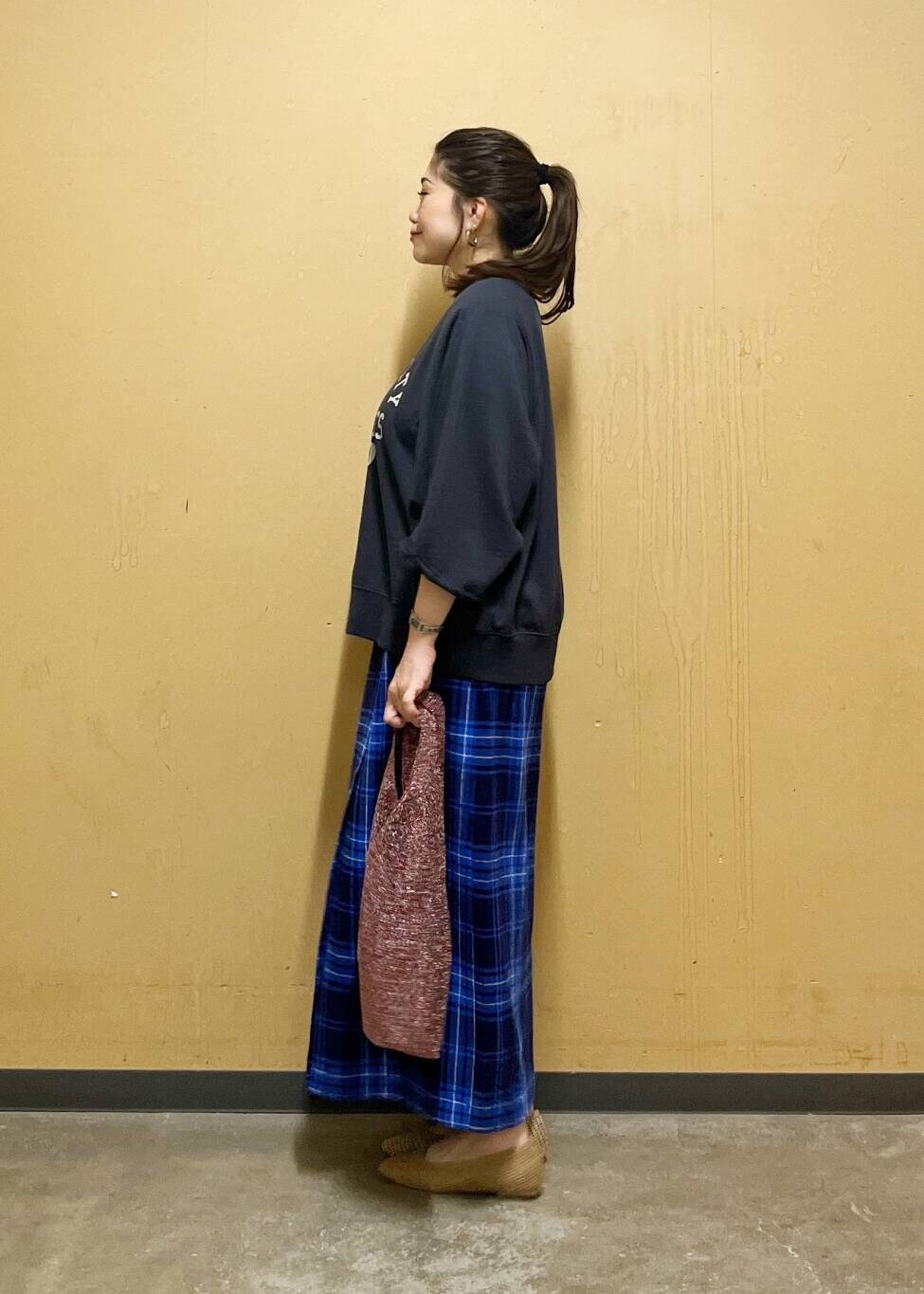 ブルー系のスカート、ベージュ系のパンプス、ブラック系のTシャツ/カットソーを着用したレディースの夏コーディネートの4枚目の写真