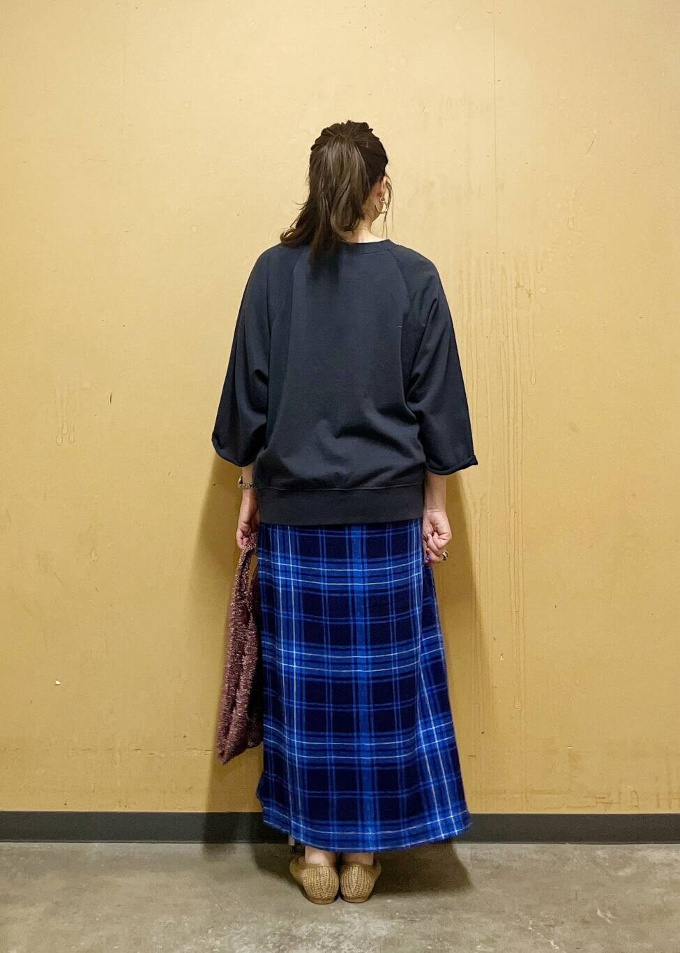 ブルー系のスカート、ベージュ系のパンプス、ブラック系のTシャツ/カットソーを着用したレディースの夏コーディネートの3枚目の写真