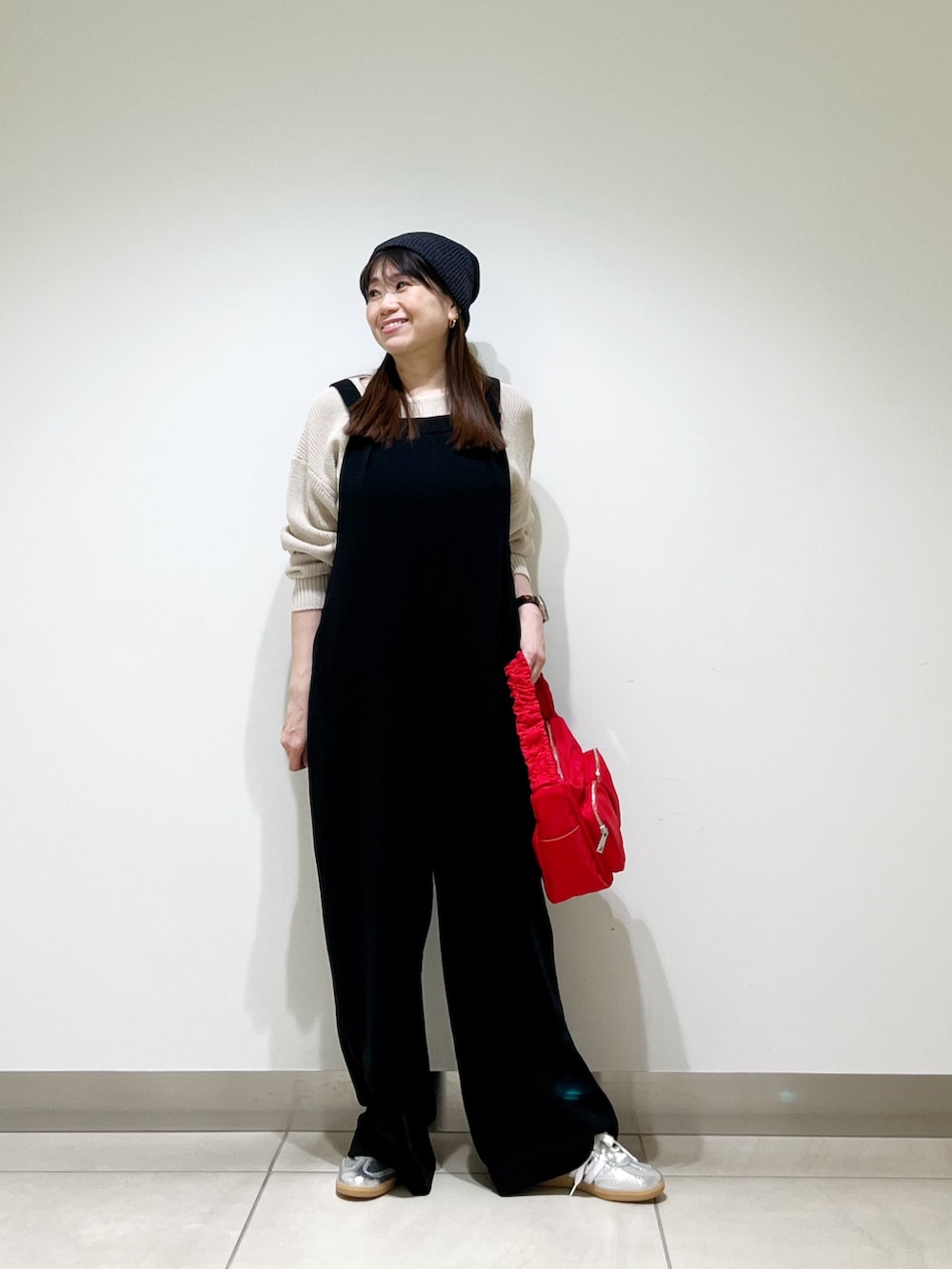 ブラック系のサロペット/オーバーオール、ベージュ系のニット/セーター、ブラウン系のショルダーバッグを着用したレディースの春コーディネートの4枚目の写真