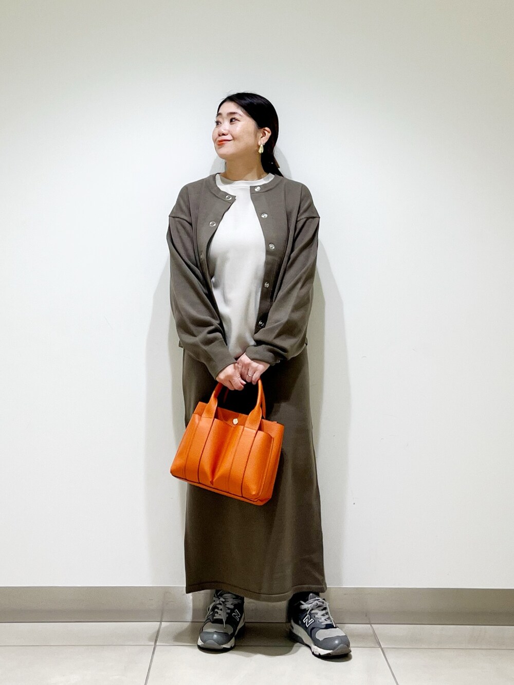 ベージュ系のTシャツ/カットソー、ブラウン系のカーディガン/ボレロ、ブラウン系のスカートを着用したレディースの秋コーディネートの4枚目の写真