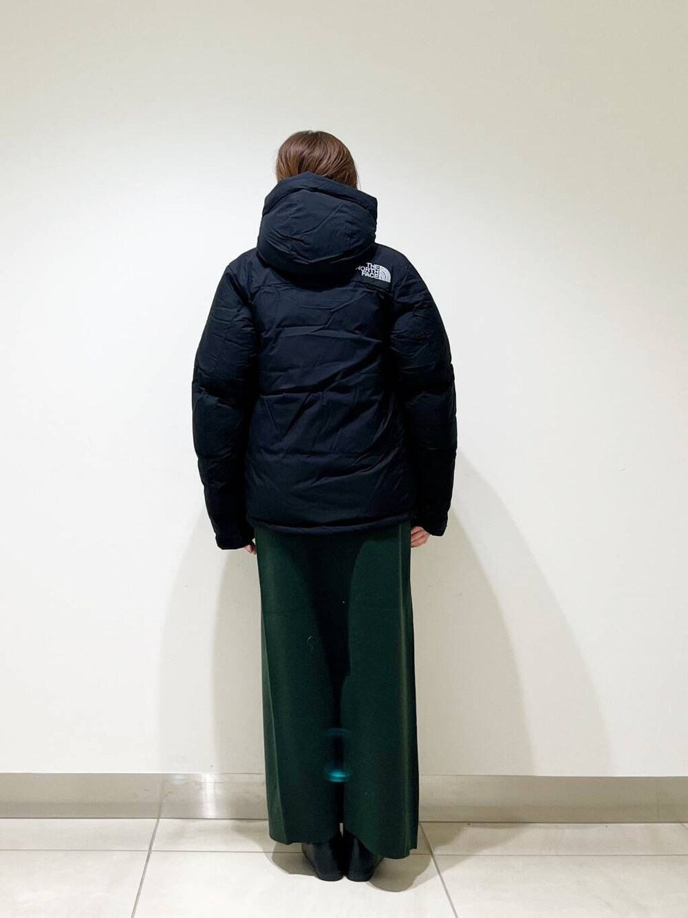 ブラック系のローファー、ブラック系のTシャツ/カットソー、グリーン系のスカートを着用したレディースの冬コーディネートの3枚目の写真