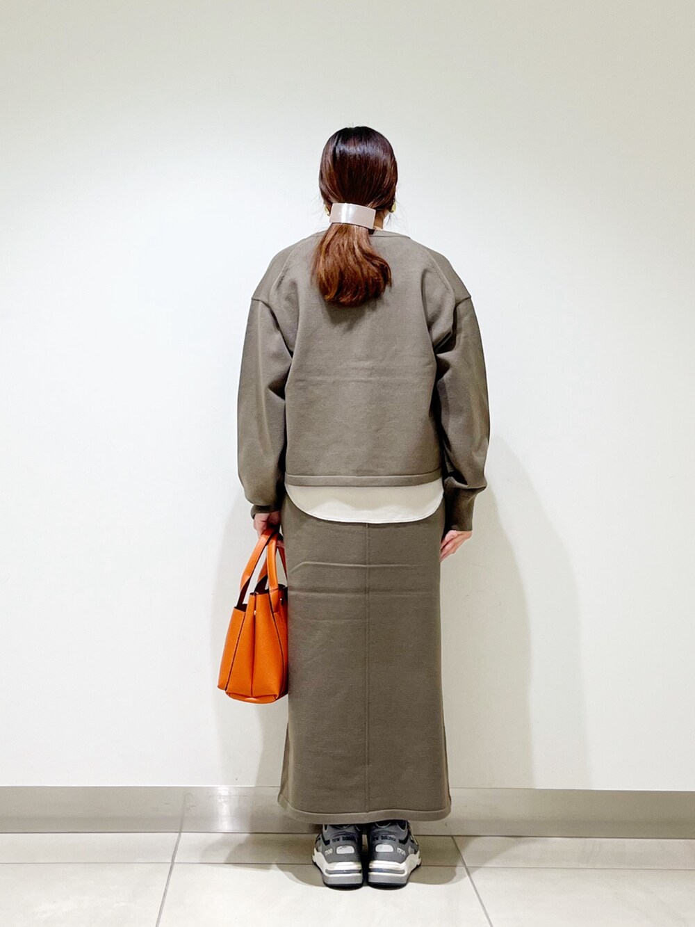 ベージュ系のTシャツ/カットソー、ブラウン系のカーディガン/ボレロ、ブラウン系のスカートを着用したレディースの秋コーディネートの7枚目の写真