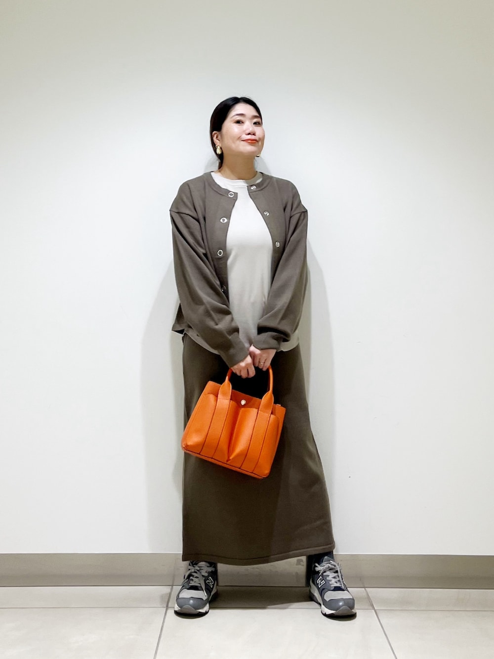 ベージュ系のTシャツ/カットソー、ブラウン系のカーディガン/ボレロ、ブラウン系のスカートを着用したレディースの秋コーディネートの3枚目の写真