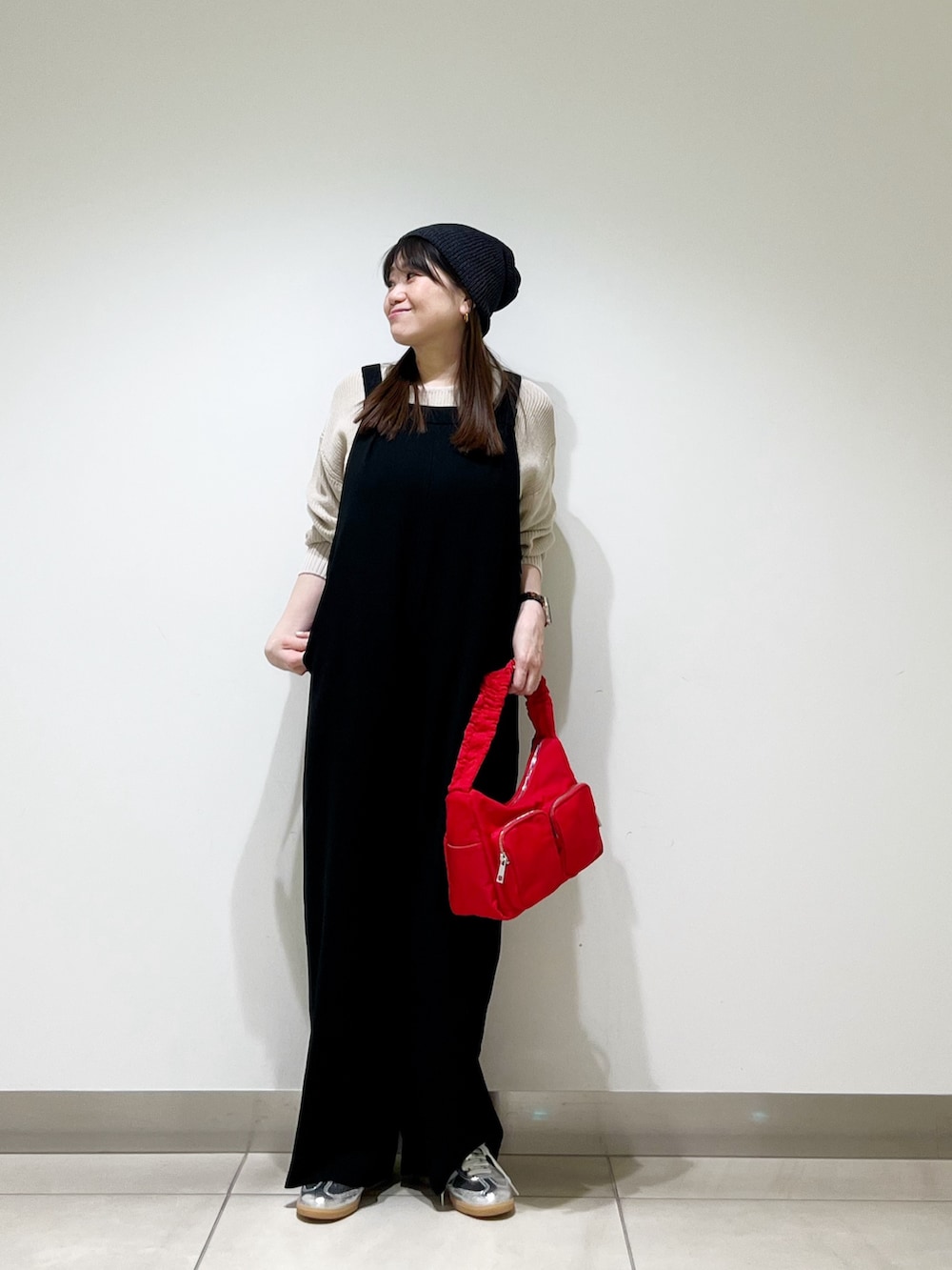 ブラック系のサロペット/オーバーオール、ベージュ系のニット/セーター、ブラウン系のショルダーバッグを着用したレディースの春コーディネートの3枚目の写真