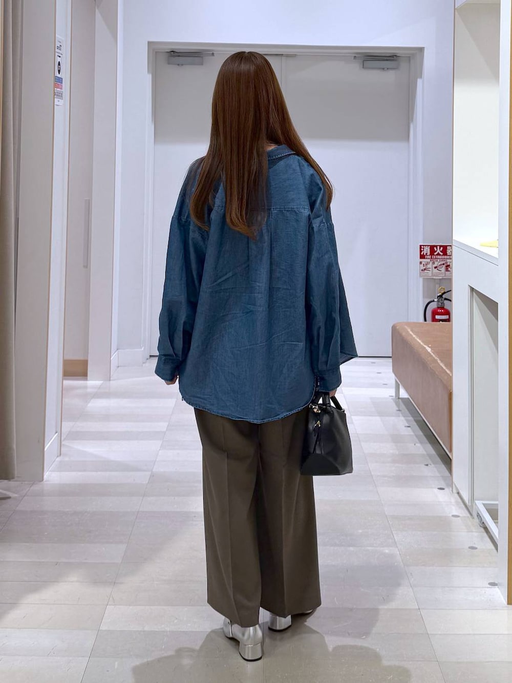 ブラック系のショルダーバッグ、ブルー系のシャツ/ブラウス、ブラック系のキャミソールを着用したレディースの春コーディネートの3枚目の写真