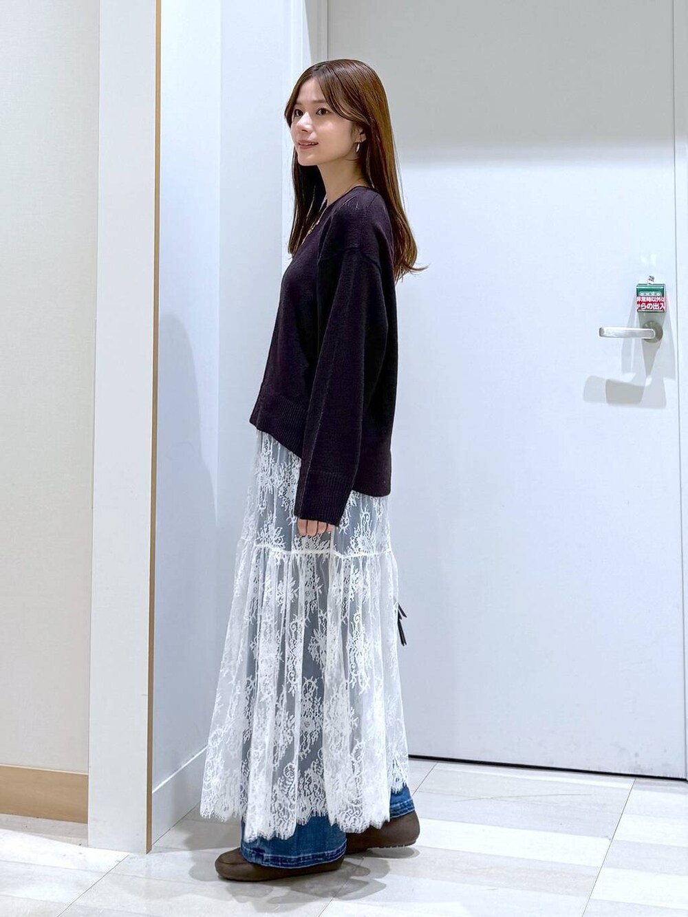 ブラウン系のワンピース、ブラウン系のローファー、ブラック系のボストンバッグを着用したレディースの秋コーディネートの2枚目の写真