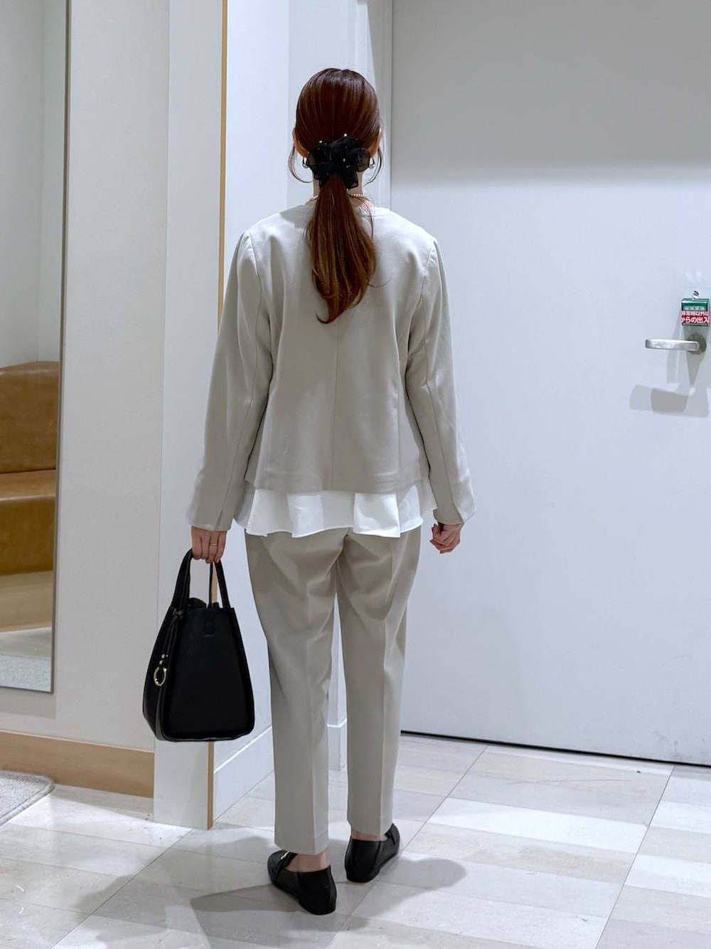 ブラック系のローファー、ブラック系のトートバッグ、ベージュ系のセットアップを着用したレディースの冬コーディネートの3枚目の写真