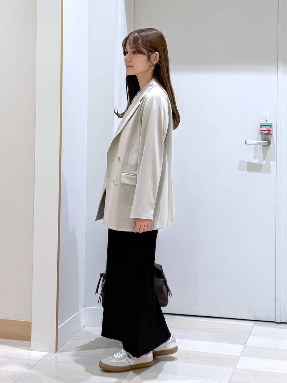 ホワイト系のスニーカー、ブラウン系のボストンバッグ、ホワイト系のTシャツ/カットソーを着用したレディースの春コーディネートの2枚目の写真