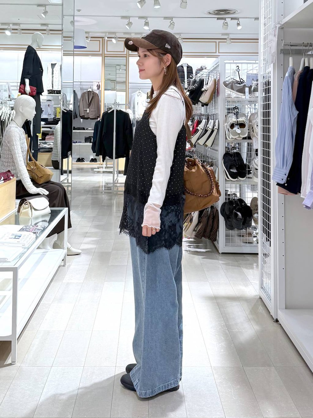 グレー系のスニーカー、ホワイト系のTシャツ/カットソー、ブラウン系のショルダーバッグを着用したレディースの秋コーディネートの2枚目の写真