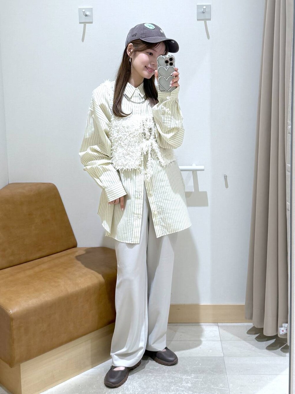 イエロー系のシャツ/ブラウス、ベージュ系のその他パンツ、ホワイト系のベストを着用したレディースの春コーディネートの2枚目の写真