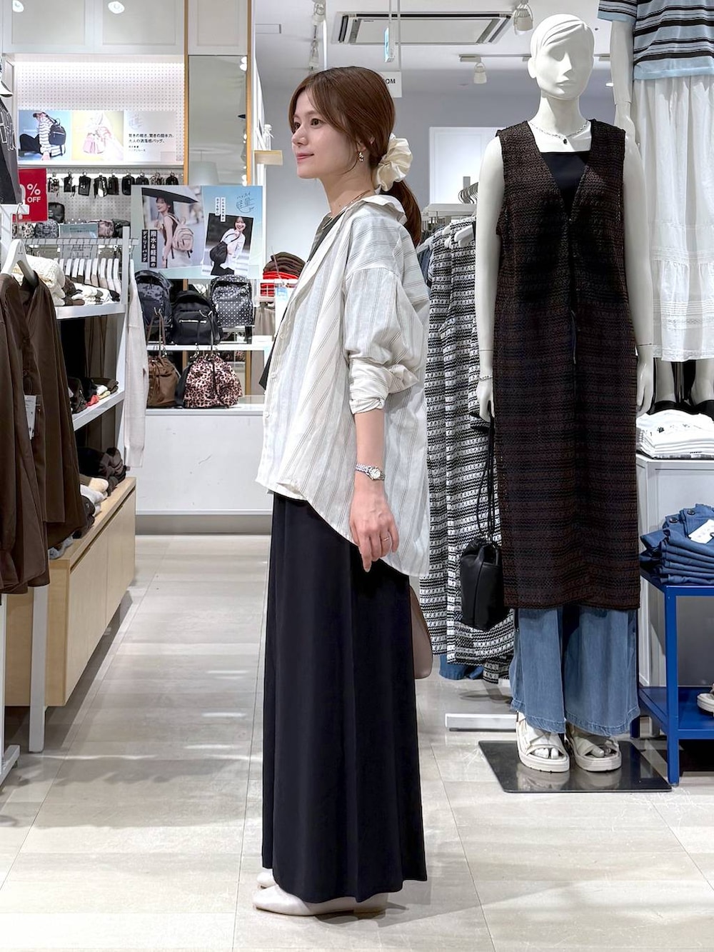 ベージュ系のパンプス、ホワイト系のショルダーバッグ、グレー系のTシャツ/カットソーを着用したレディースの夏コーディネートの2枚目の写真