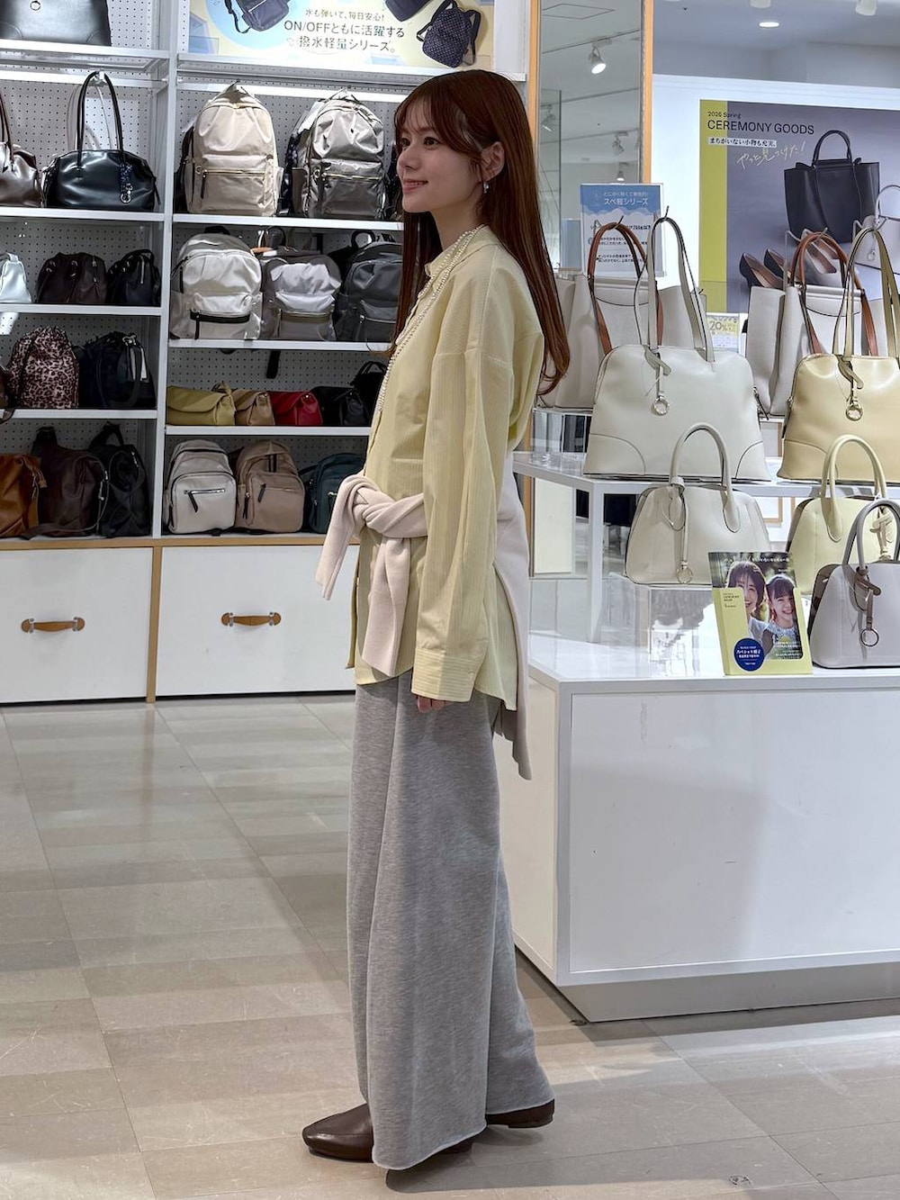 イエロー系のシャツ/ブラウス、グレー系のスウェットパンツ、ベージュ系のカーディガン/ボレロを着用したレディースの春コーディネートの2枚目の写真