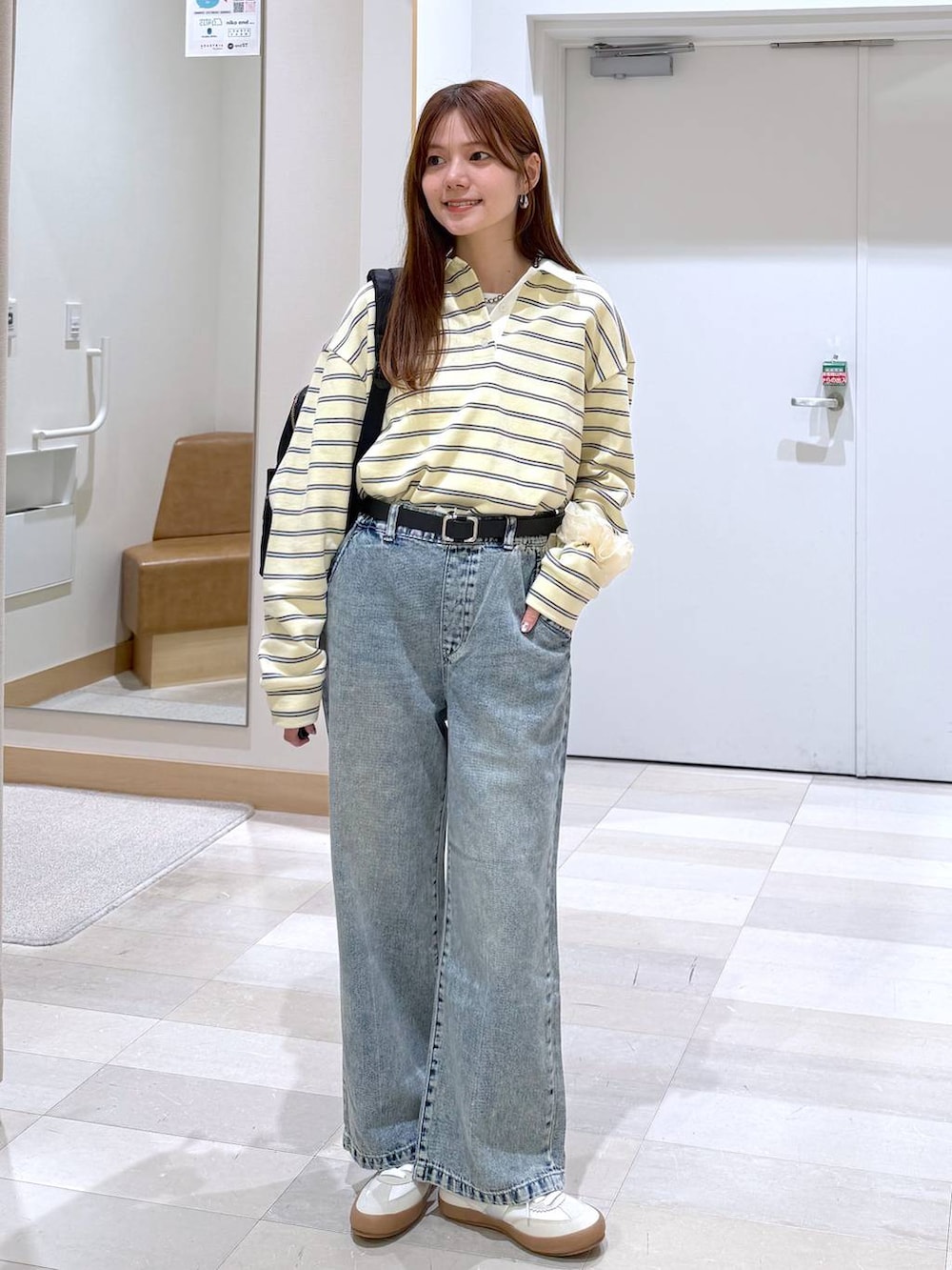 ホワイト系のスニーカー、ブラック系のバックパック/リュック、ブルー系のデニムパンツを着用したレディースの春コーディネートの2枚目の写真