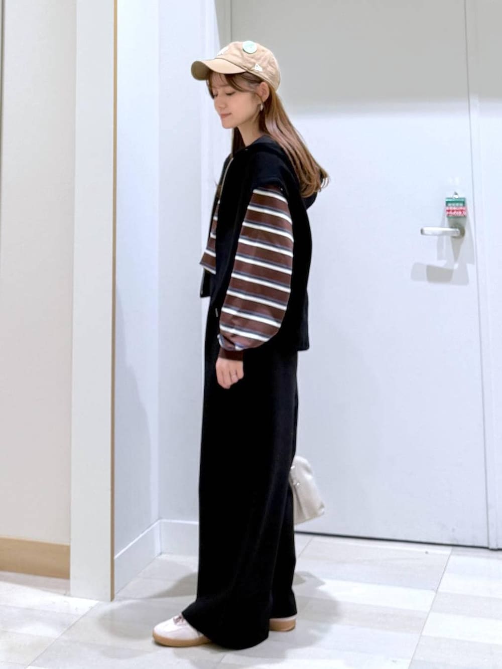 ホワイト系のボストンバッグ、ブラック系のスウェットパンツ、ブラウン系のTシャツ/カットソーを着用したレディースの冬コーディネートの2枚目の写真