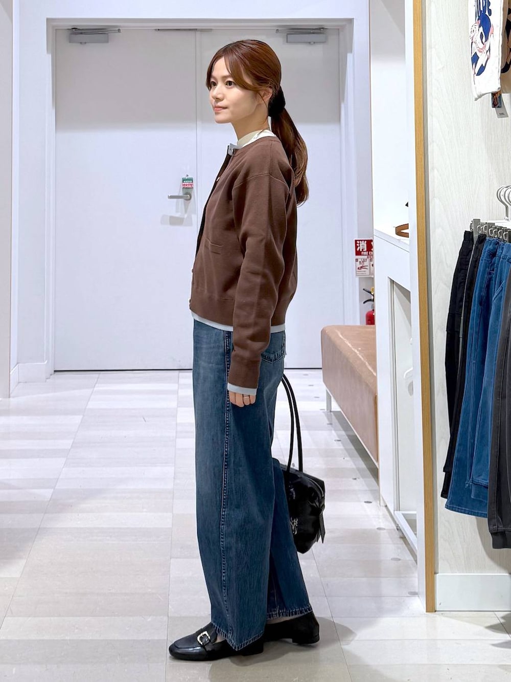 ブラック系のローファー、ブラック系のボストンバッグ、ホワイト系のニット/セーターを着用したレディースの冬コーディネートの2枚目の写真