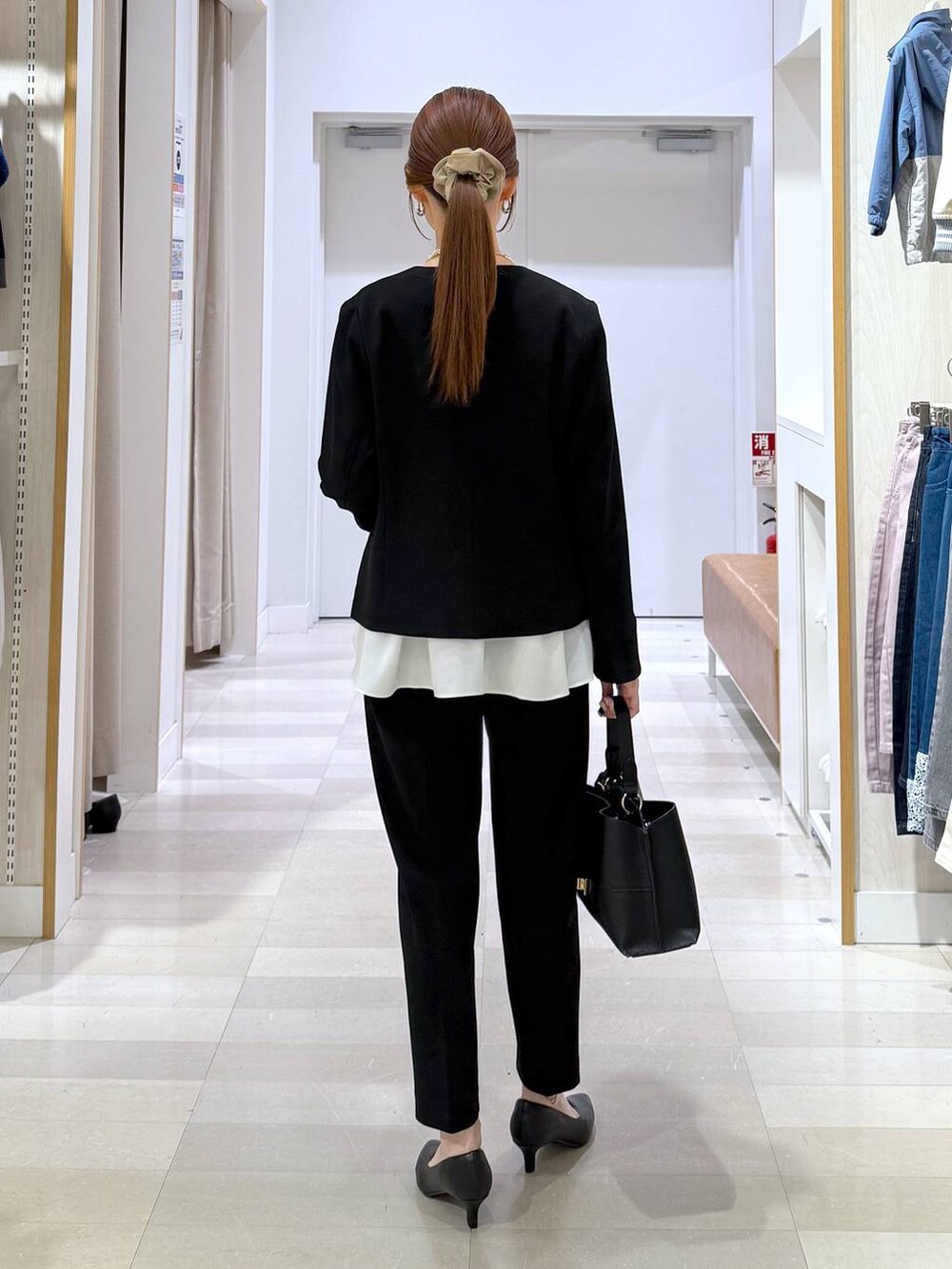 ブラック系のパンプス、ブラック系のセットアップ、ブラック系のショルダーバッグを着用したレディースの冬コーディネートの3枚目の写真