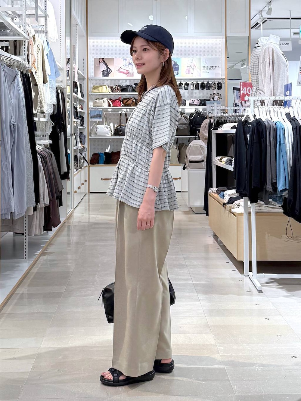 ベージュ系のその他パンツ、ブラック系のサンダル、グレー系のTシャツ/カットソーを着用したレディースの夏コーディネートの2枚目の写真