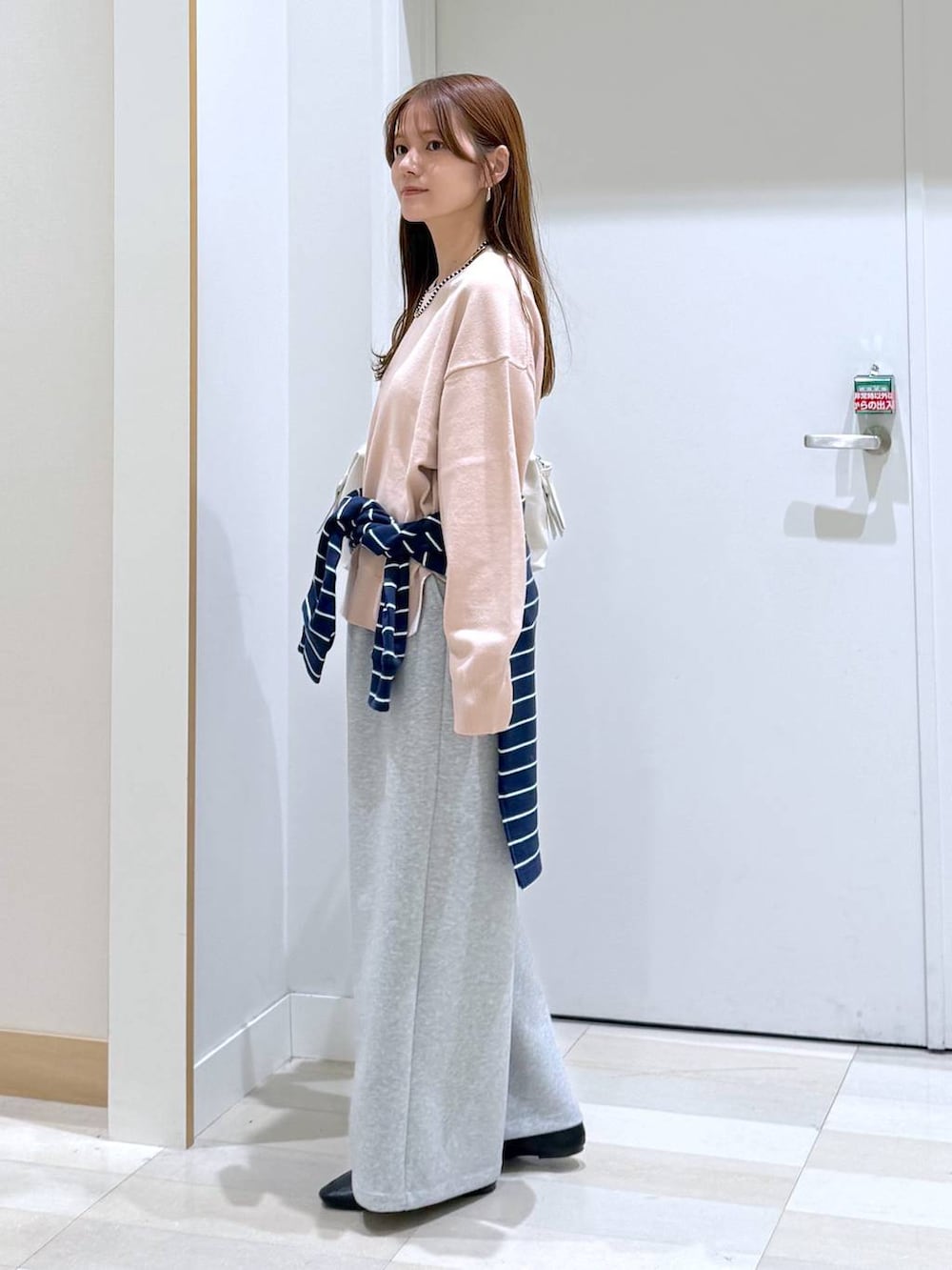 ブラック系のその他シューズ、ホワイト系のボストンバッグ、グレー系のスウェットパンツを着用したレディースの春コーディネートの2枚目の写真