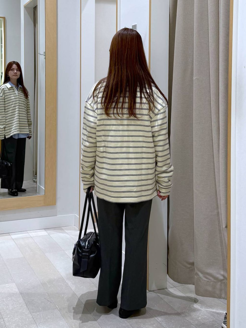 ブラック系のローファー、ブラック系のボストンバッグ、ブルー系のシャツ/ブラウスを着用したレディースの春コーディネートの3枚目の写真