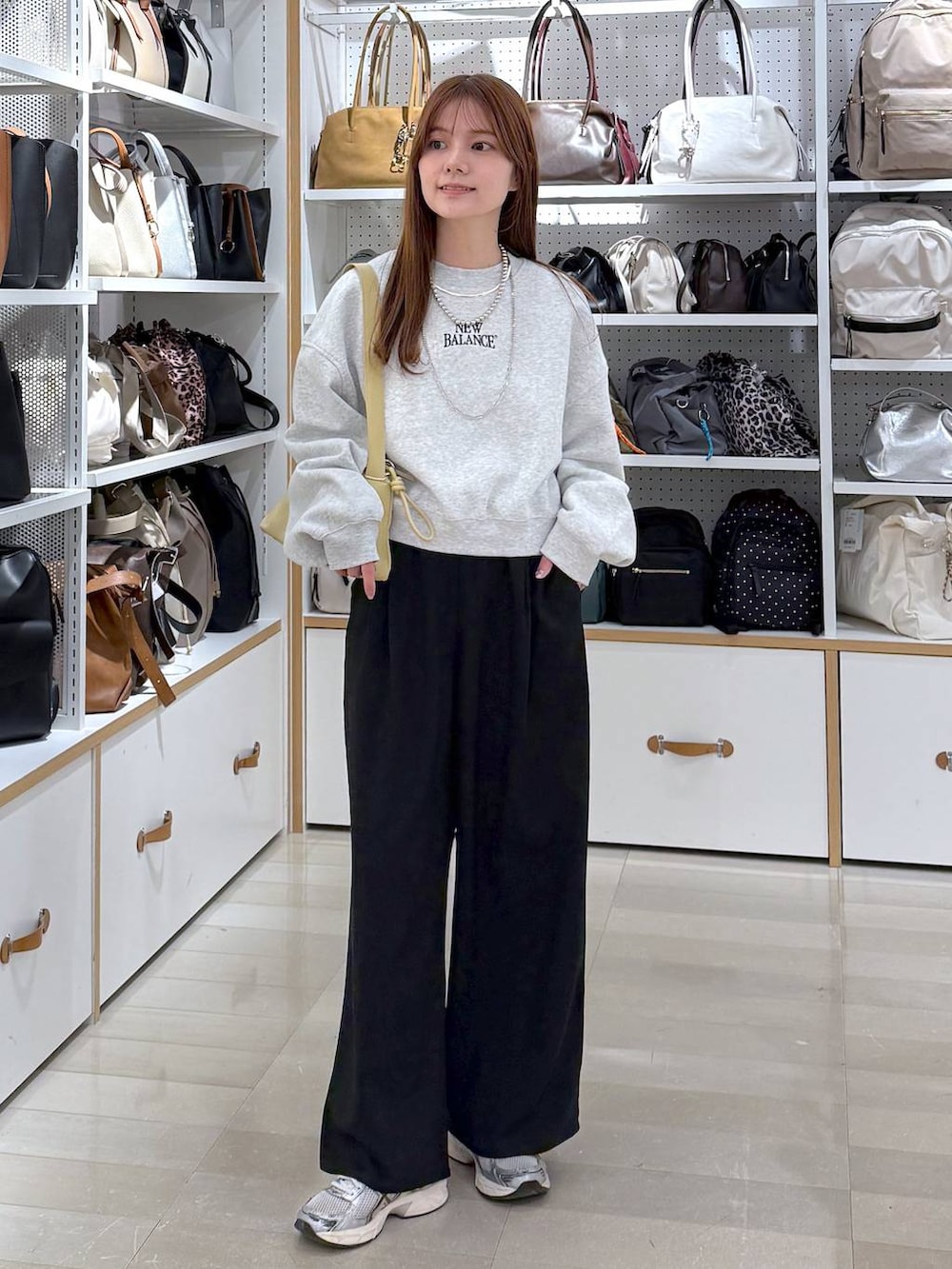 ブラック系のその他パンツ、イエロー系のショルダーバッグ、シルバー系のネックレスを着用したレディースの冬コーディネートの4枚目の写真