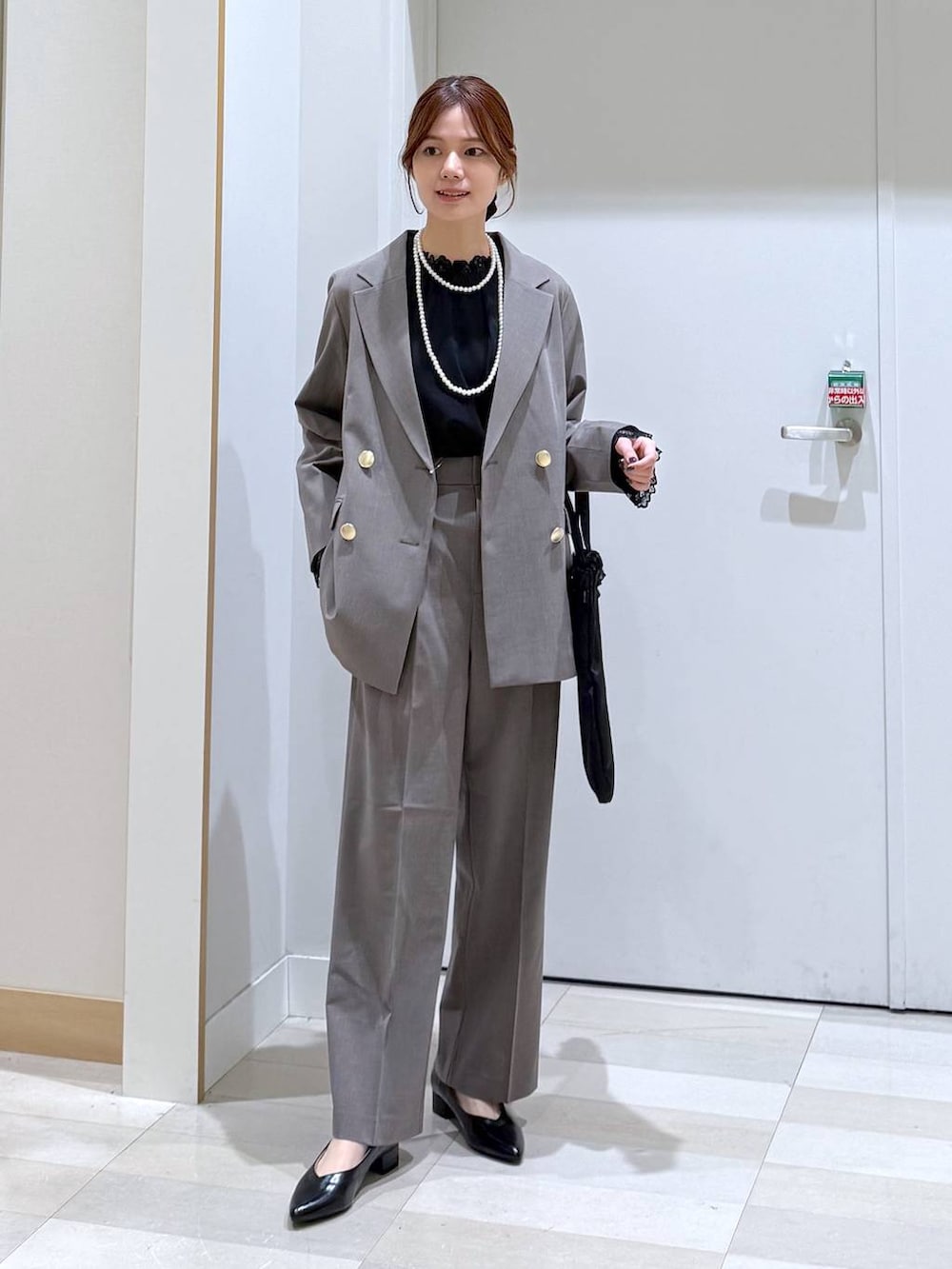 ブラック系のパンプス、ブラック系のシャツ/ブラウス、ブラウン系のスラックスを着用したレディースの冬コーディネートの4枚目の写真