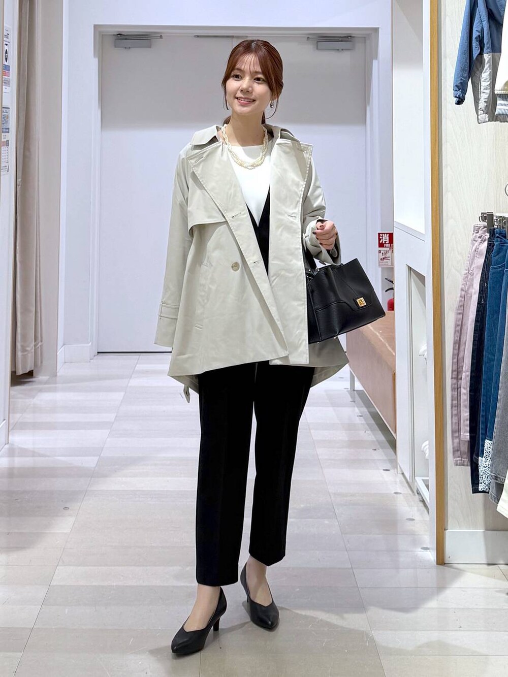 ブラック系のパンプス、ブラック系のセットアップ、ブラック系のショルダーバッグを着用したレディースの冬コーディネートの5枚目の写真