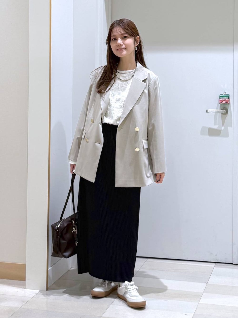 ホワイト系のスニーカー、ブラウン系のボストンバッグ、ホワイト系のTシャツ/カットソーを着用したレディースの春コーディネートの4枚目の写真