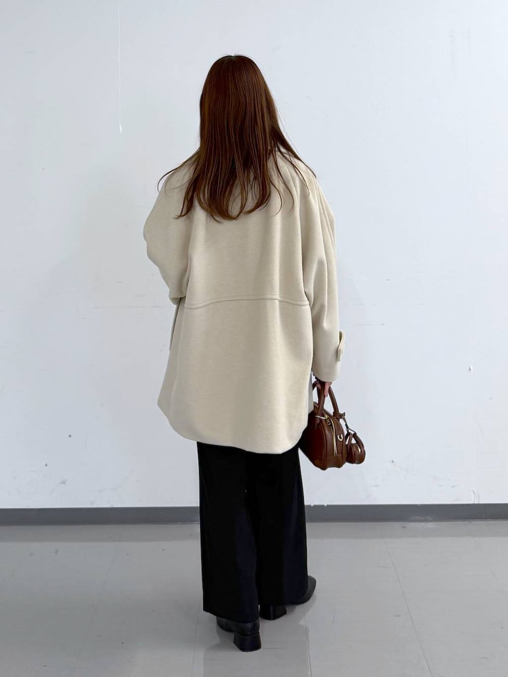 ホワイト系のニット/セーター、ブラック系のその他パンツ、ホワイト系のTシャツ/カットソーを着用したレディースの冬コーディネートの3枚目の写真