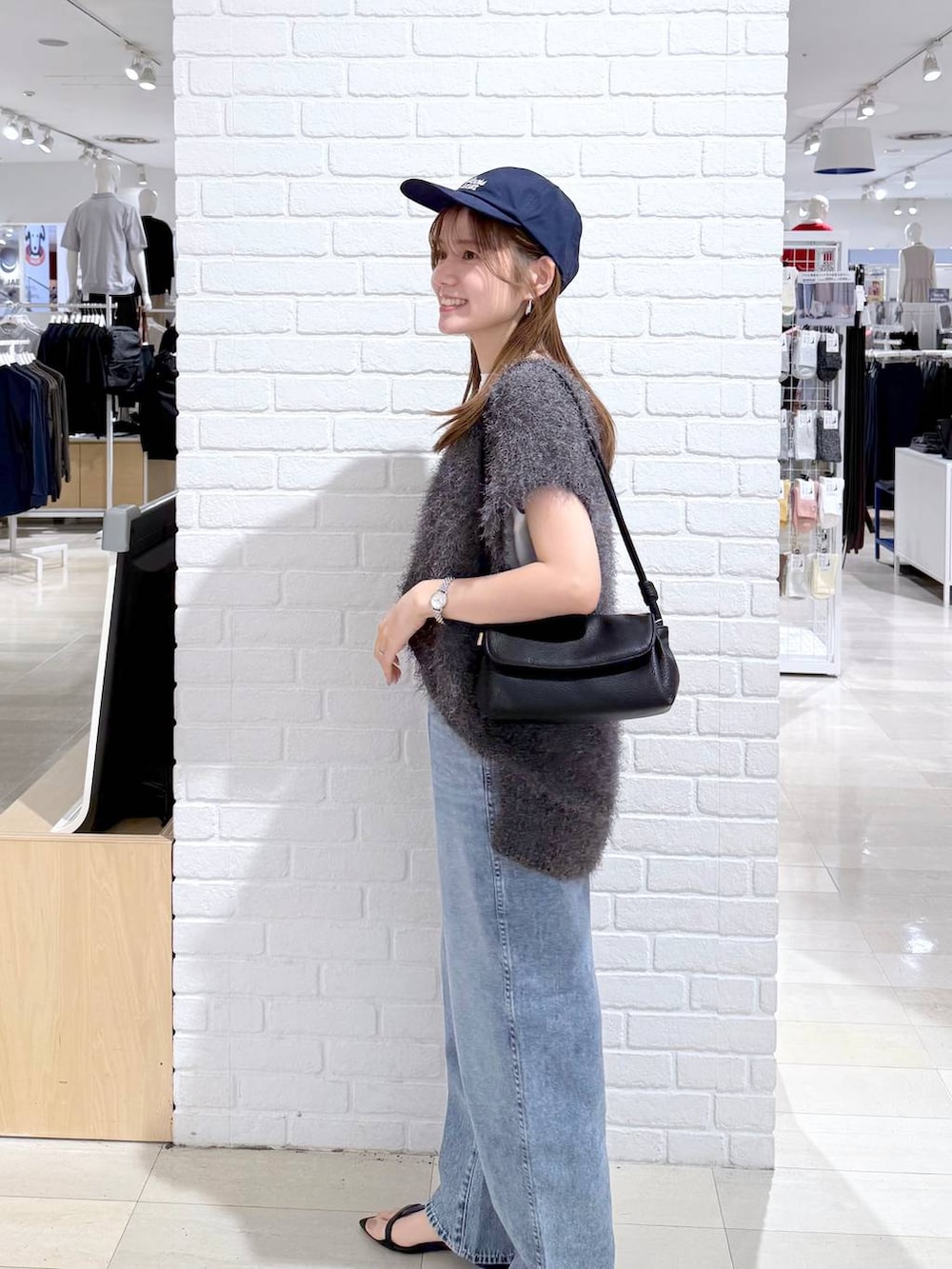 ブルー系のデニムパンツ、ホワイト系のTシャツ/カットソー、ブラック系のショルダーバッグを着用したレディースの秋コーディネートの3枚目の写真