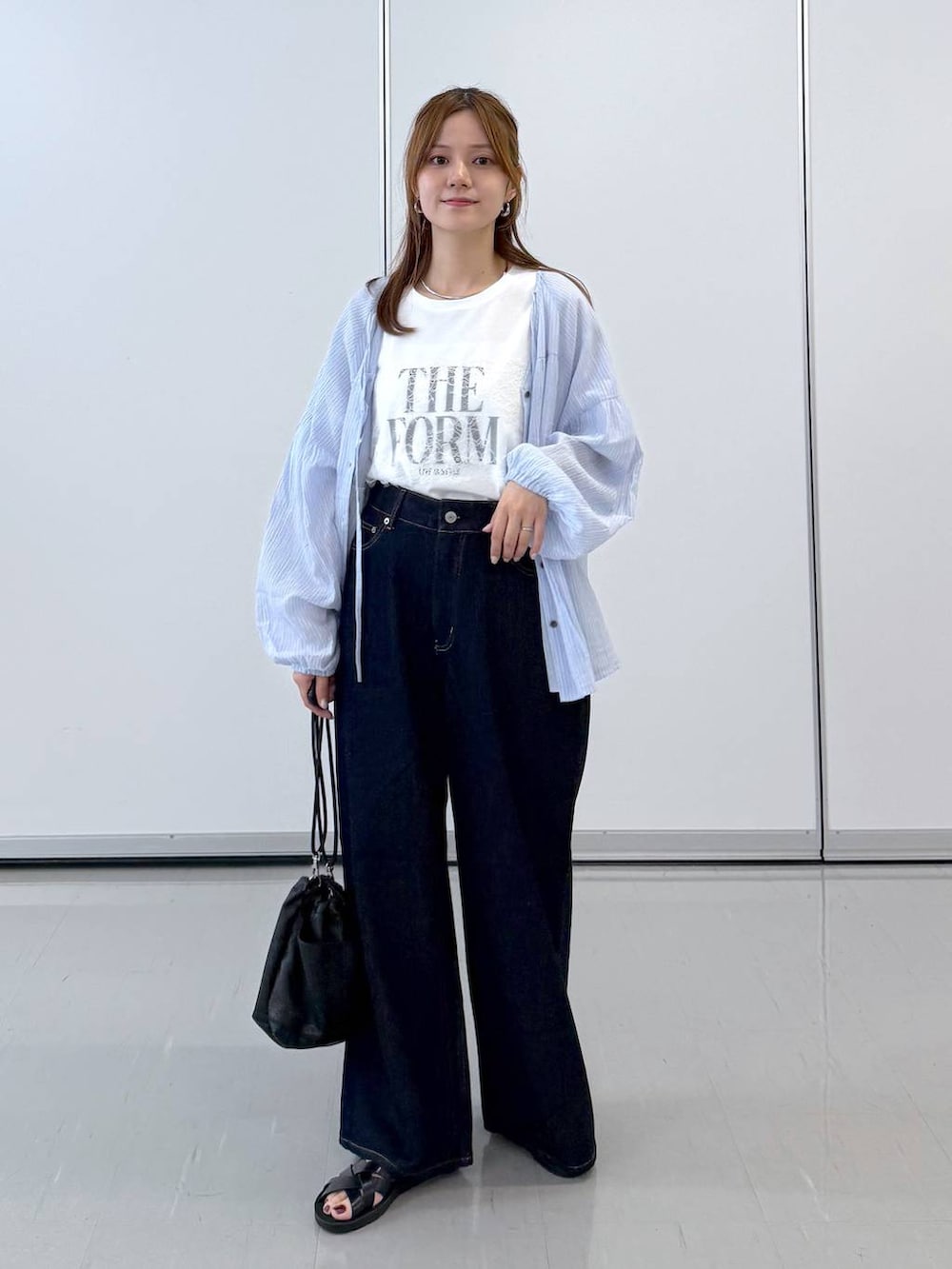 ブラック系のボディバッグ/ウエストポーチ、ブラック系のサンダル、ホワイト系のTシャツ/カットソーを着用したレディースの夏コーディネートの4枚目の写真