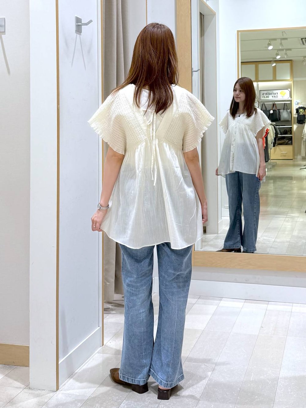 ブルー系のデニムパンツ、ホワイト系のタンクトップ、ベージュ系のシャツ/ブラウスを着用したレディースの夏コーディネートの3枚目の写真