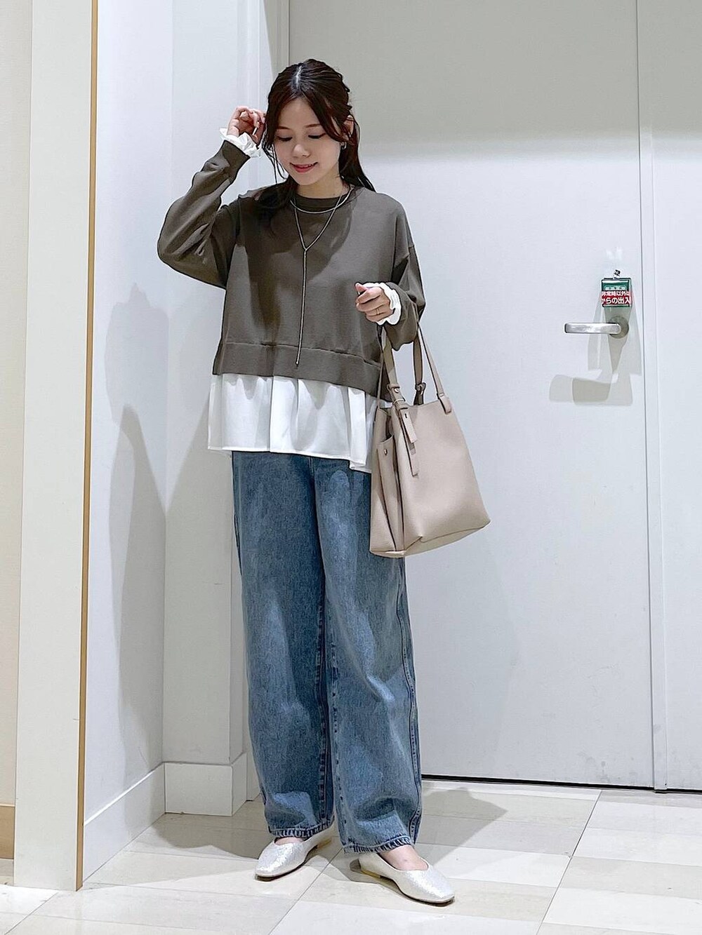 ブルー系のデニムパンツ、ブラウン系のニット/セーター、グレー系のパンプスを着用したレディースの春コーディネートの4枚目の写真