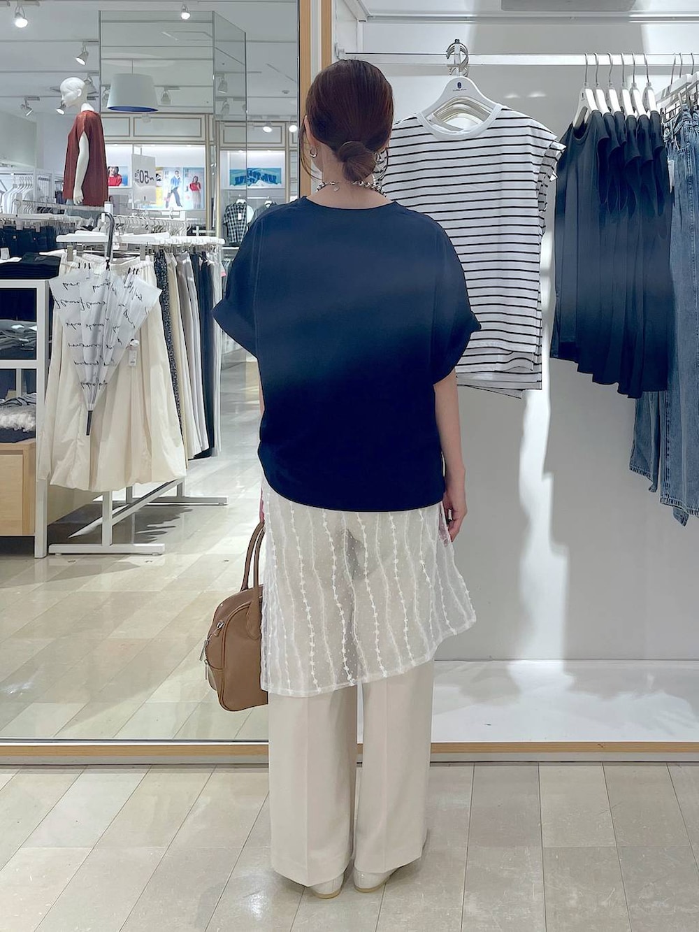 ベージュ系のパンプス、ベージュ系のボストンバッグ、ブルー系のTシャツ/カットソーを着用したレディースの夏コーディネートの3枚目の写真