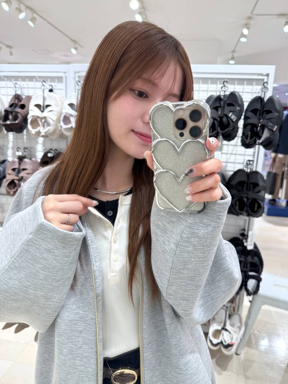 ブラウン系のボストンバッグ、ブルー系のデニムパンツ、グレー系のブルゾンを着用したレディースの春コーディネートの5枚目の写真