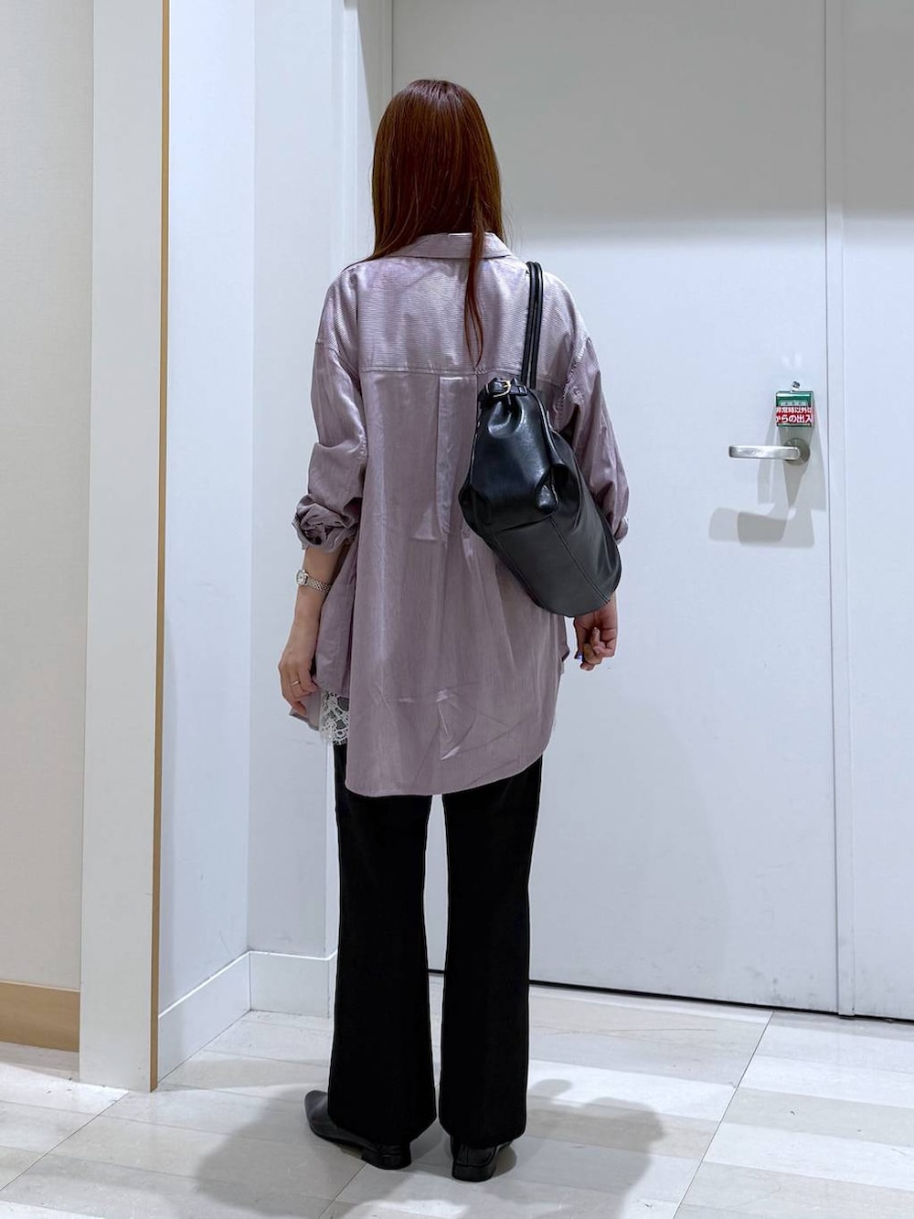ブラック系のボストンバッグ、ブラック系のパンプス、ホワイト系のキャミソールを着用したレディースの秋コーディネートの3枚目の写真