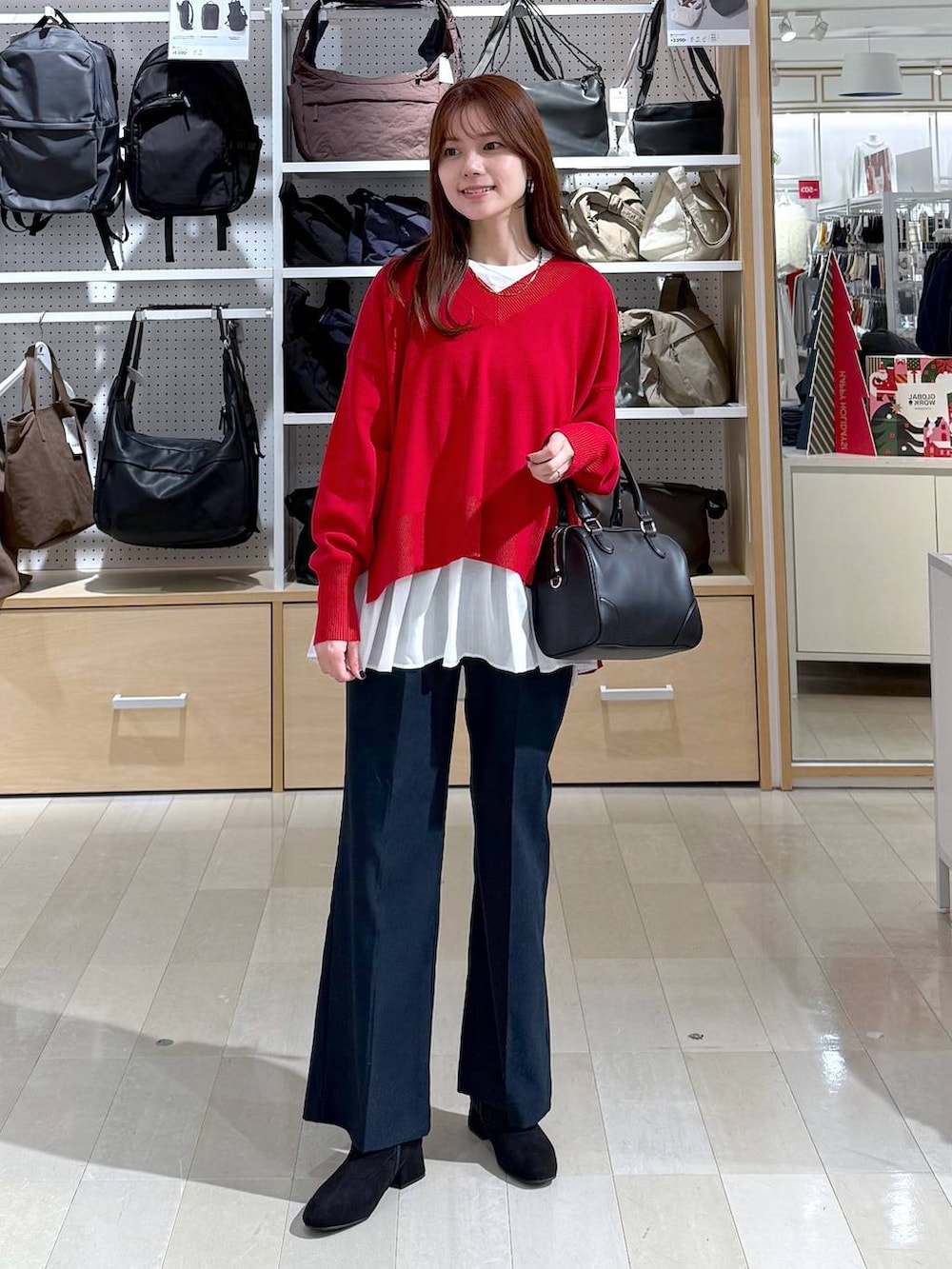 ブラック系のダウンジャケット/コート、レッド系のニット/セーター、ブルー系のその他パンツを着用したレディースの冬コーディネートの5枚目の写真